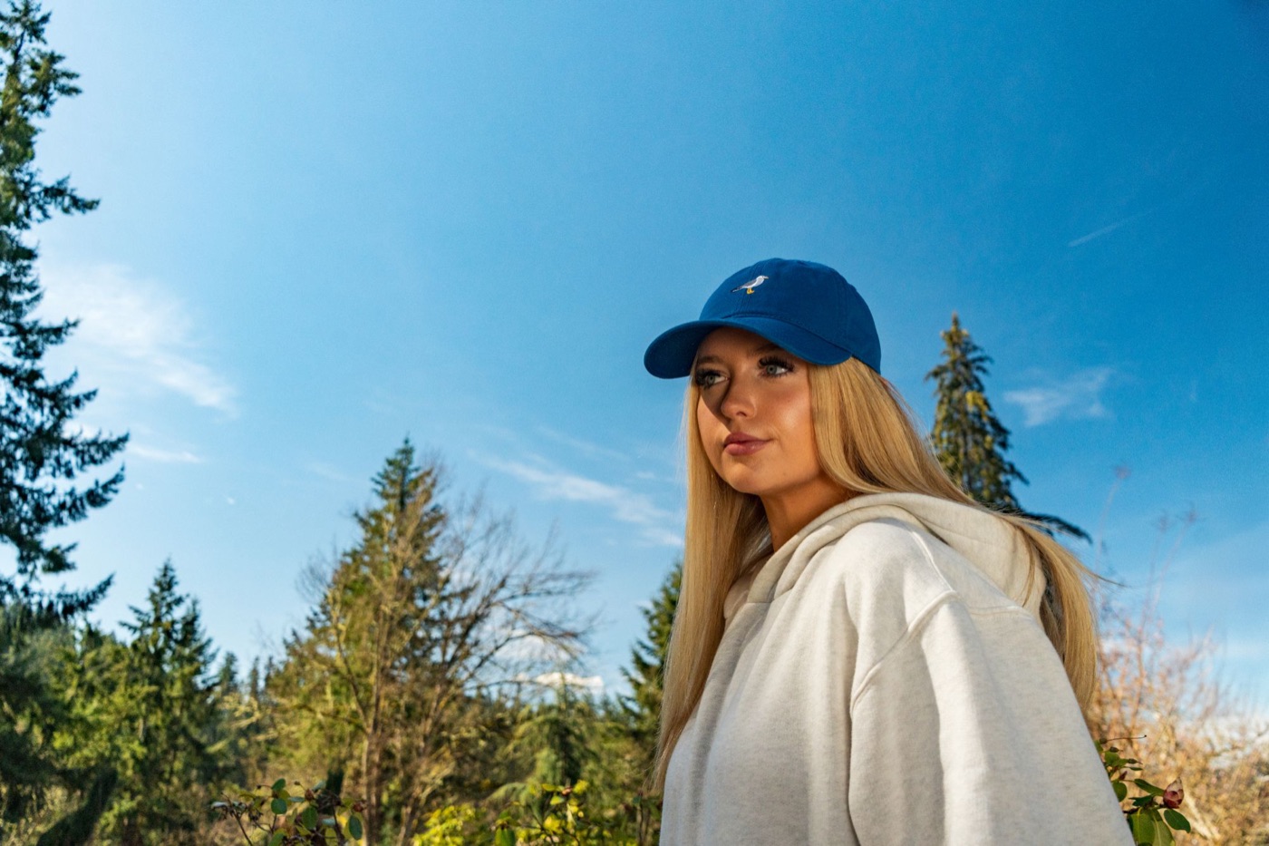Model in a blue seagull cap against a bright blue sky
