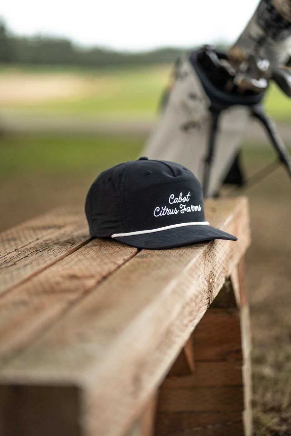 Cabot Citrus Farms rope cap resting on a wooden bench