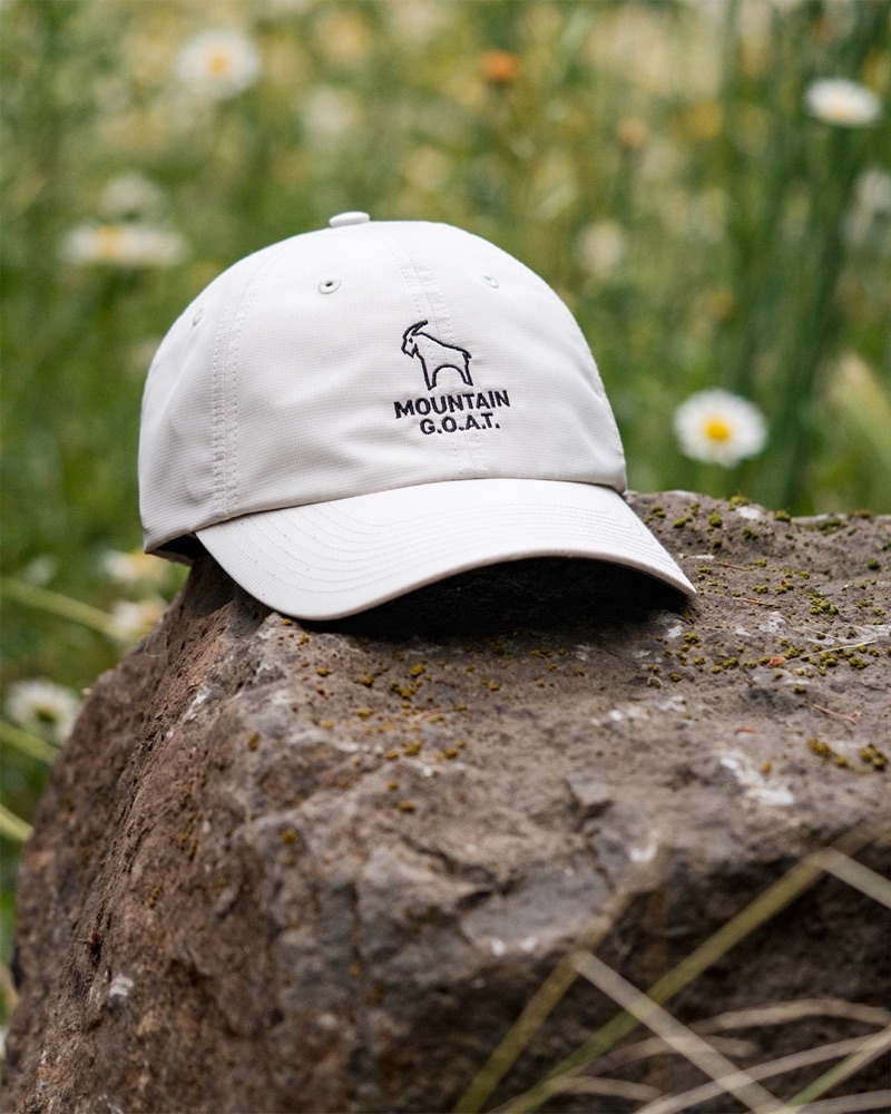 Slide 1: Mountain G.O.A.T. cap on a rock