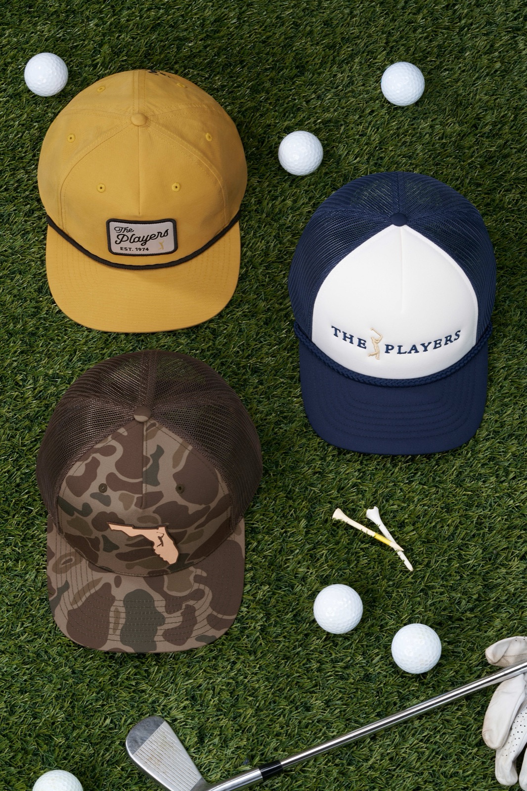 PLAYERS collection caps in camo, gold, and navy on turf