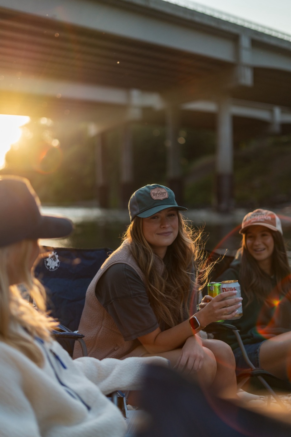 Smiling woman in a Heisler patch cap with sun flare behind her